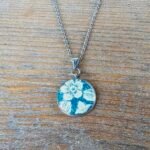 Collier argenté Éclosion d’Émeraude – Pendentif rond fleuri en assiette ancienne
